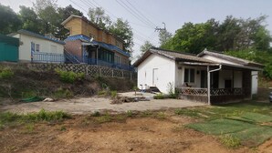 Un quartier résidentiel avec des maisons, un chemin de terre et une zone herbeuse.