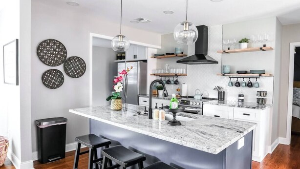 A modern kitchen with a central island, bar stools, a stainless steel refrigerator, and a black range hood. - ❤️ Heart of Tech Terrace 3/2 Remodeled Near Tech (Lubbock)