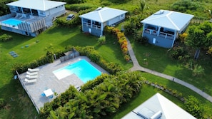 Ein Wohnhaus mit Schwimmbad, mehreren Gebäuden und üppiger Bepflanzung.