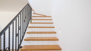 Eine Treppe mit Holzstufen und einem schwarzen Metallgeländer.