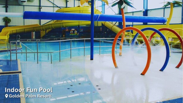 An indoor fun pool with a water slide and colorful rings. - Golden Palm Resort (Skegness)