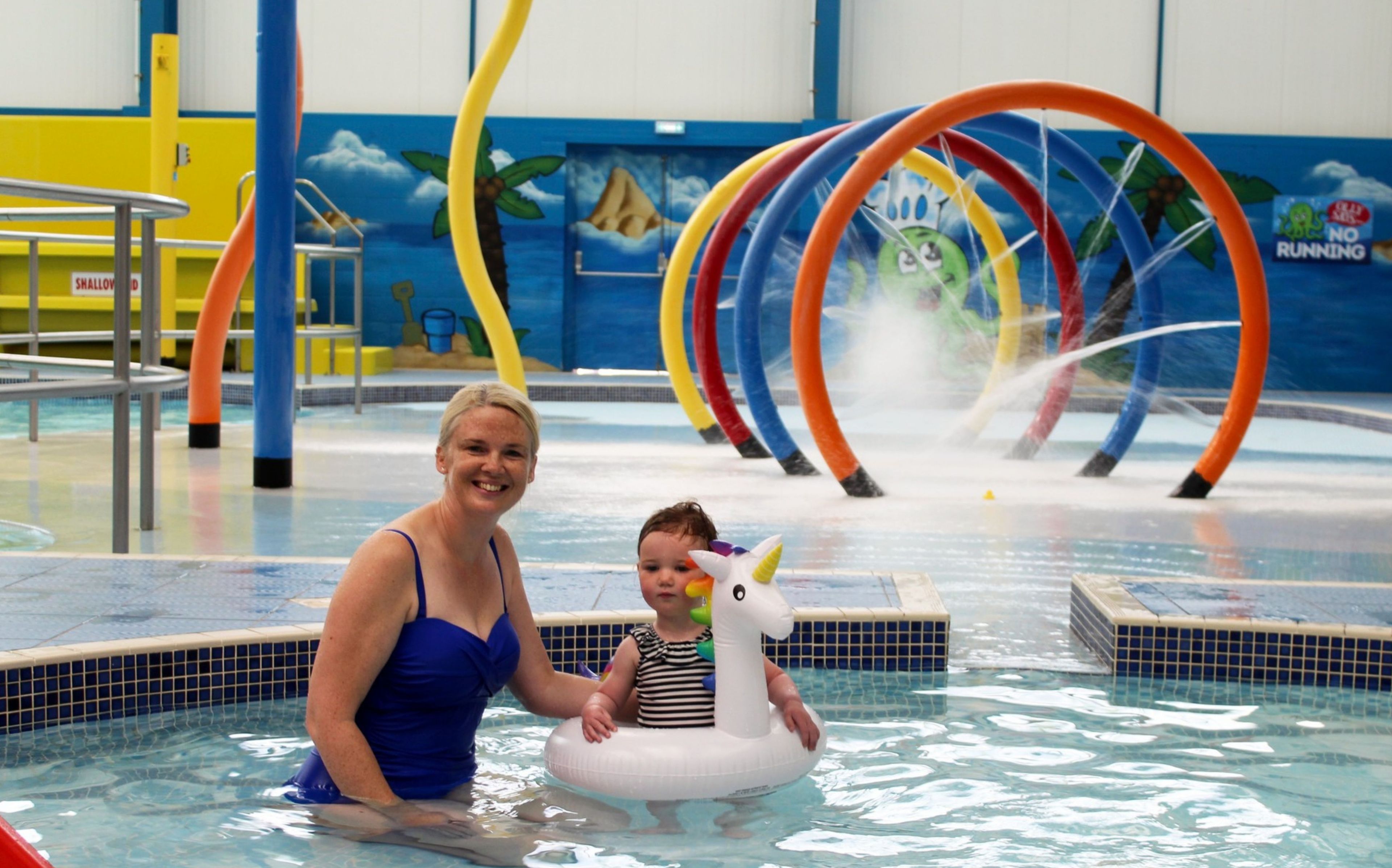 An indoor pool area with a water play structure and a sign indicating 'Indoor Fun Pool' at Golden Palm Resort.