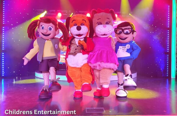 A stage with four characters in costumes, a VIP pass, and the text "Childrens Entertainment" and "Golden Palm Resort". - Golden Palm Resort (Skegness)