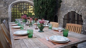 A wooden table set for dining with plates, glasses, and a vase of flowers. - Stone farmhouse with large pool in Ménerbes, Luberon (Ménerbes)