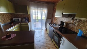 A compact kitchen with a microwave, stove, and sink. - Abgeschlossene Ferienwohnung (Altendiez)