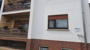 A multi-story building with balconies, windows, and a brick facade. - Abgeschlossene Ferienwohnung (Altendiez)