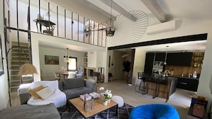 A spacious living area with a staircase, a dining area, and a kitchen.
