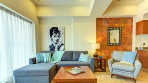 A modern living room with a sectional sofa, a small table, and a single armchair.