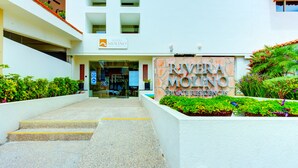 A building entrance with a sign for Riviera Molino Private Residences.