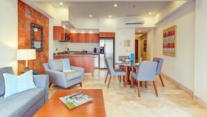 A modern living room with a sofa, coffee table, and dining area with chairs and a table.
