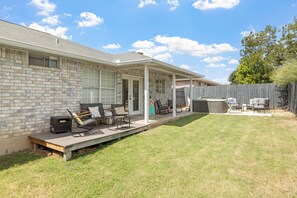 Un patio couvert avec des meubles d’extérieur, un mur en briques et une terrasse en bois.