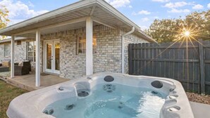 A house with a covered patio, a hot tub, and a fenced backyard. - Newly remodeled home w/ a backyard oasis, beautiful hot tub blocks from downtown (Fredericksburg)