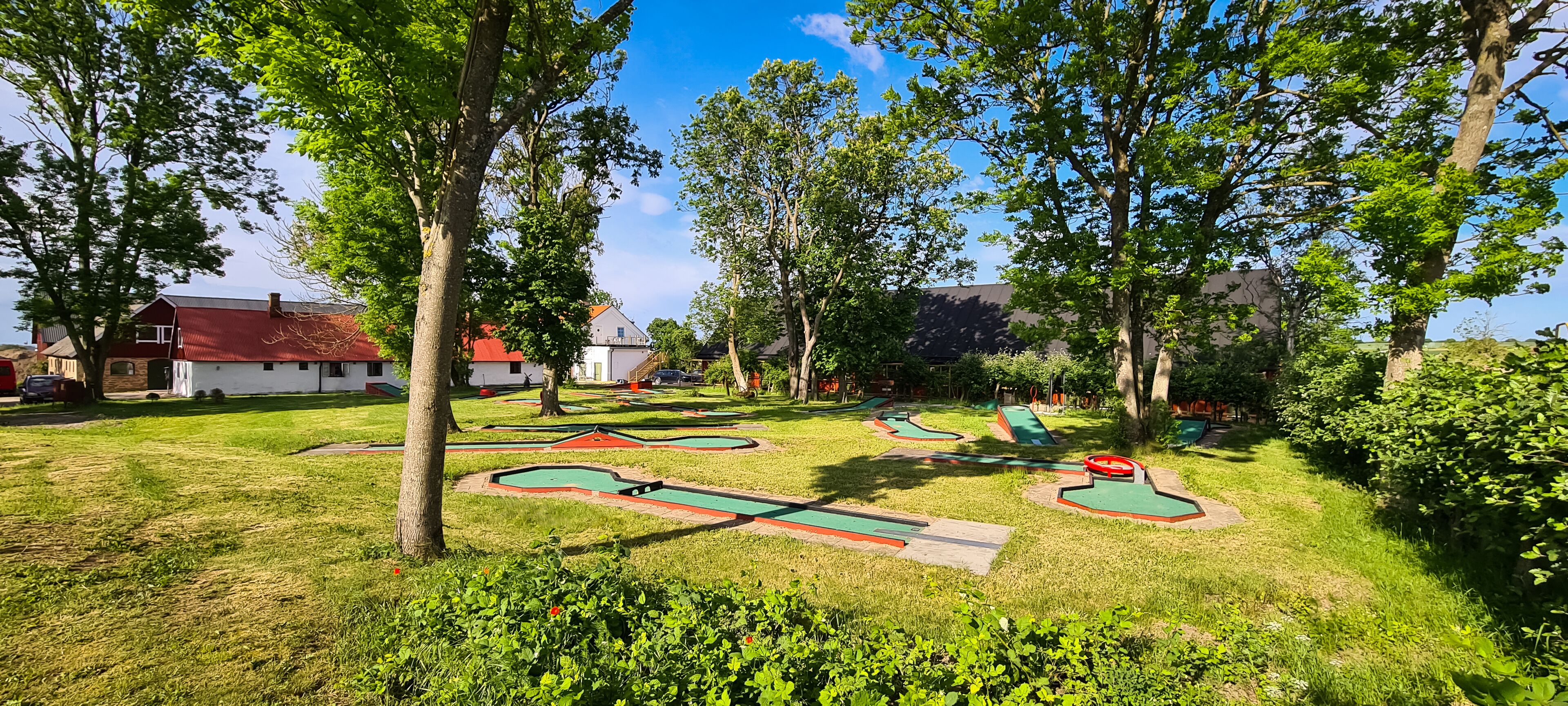 Un parc bien entretenu, doté de plusieurs parcours de mini-golf, entouré d’arbres et de pelouses.