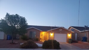 A residential house with a garage, a driveway, and a tree in the front yard. - I Deal Lake Powell Home 3BR, Jacuzzi, BBQ & Firepit (Page)