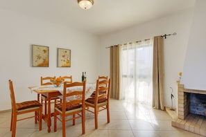 A dining area with a table, chairs, and a fireplace. - Lourenço - Amazing Villa with private pool, air/con, BBQ, Free Wi-Fi, near amenities (Albufeira)