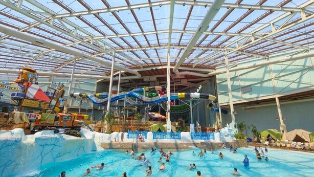 An indoor water park with multiple pools and a large water slide. - ⭐️ Spacious Mountaintop Oasis at Camelback | 2,500 SF w/ Game Room, Deck & A/C (Tannersville)