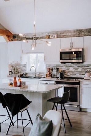 Enjoy cooking in this well-equipped kitchen with a central island, sink, and oven.
