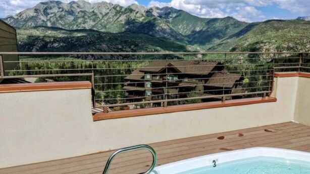 A hot tub on a wooden deck with a mountain view. - SKI-IN/OUT Charming studio condo steps to lift in the heart of Purgatory Resort! (Durango)