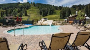 A pool area with lounge chairs, a hot tub, and a view of a mountainous landscape. - SKI-IN/OUT Charming studio condo steps to lift in the heart of Purgatory Resort! (Durango)