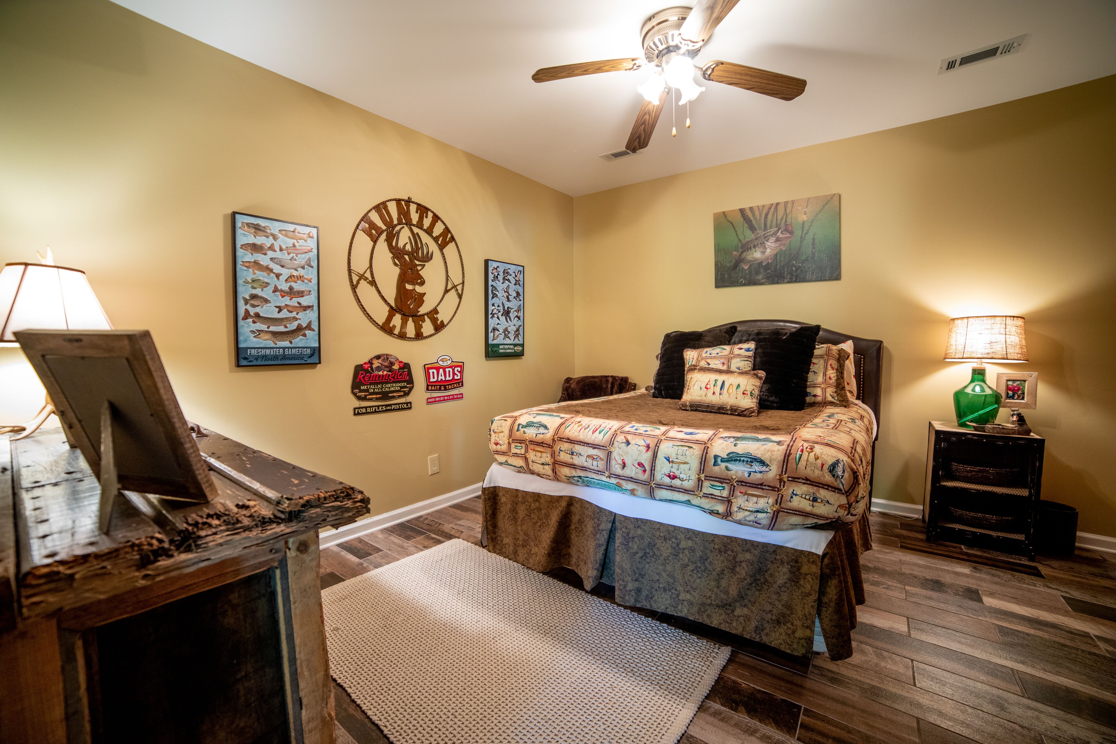 Une chambre à coucher comprenant un lit, un ventilateur de plafond, une horloge murale et divers éléments de décoration.