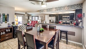 A modern kitchen with dark cabinets, a stainless steel refrigerator, and a microwave. - Private HEATED POOL at the Wine Time Villa! (Lake Havasu City)