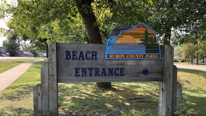 A wooden sign indicating the entrance to Beach and Huron County Parks.