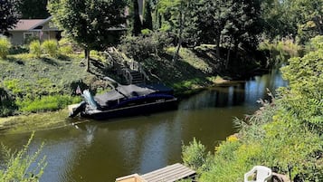 Un molo di legno che conduce a un fiume, con una barca ormeggiata sulla riva.