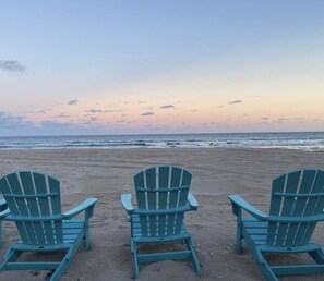 Three Adirondack chairs facing a beach with a sunset in the background. -  Beach dreaming?? (Manchester-by-the-Sea)