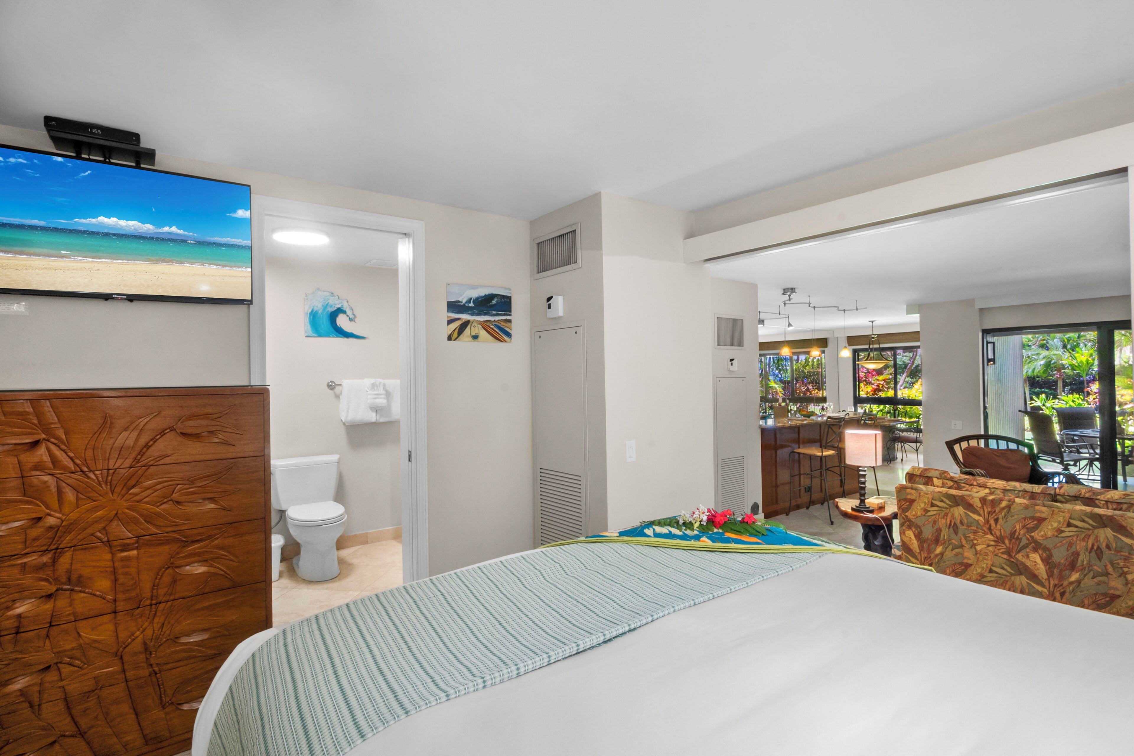Een hotelkamer met een bed, een badkamer, een eethoek en uitzicht op het omliggende landschap.