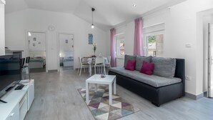 Un salon moderne comprenant un canapé, une table à manger et un coin cuisine.