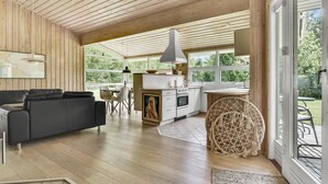 A modern kitchen with white cabinets, a stove, and a dining area with a table and chairs.