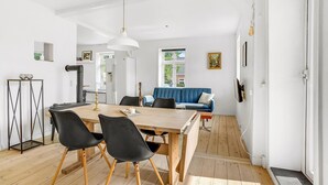 Una cucina moderna con un tavolo di legno, sedie nere e un divano blu.