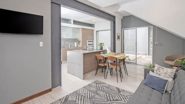 A modern apartment with a kitchen, dining area, and living room.