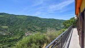A balcony with a view of a lush valley and distant buildings. - Awesome home in Sinagra with WiFi (Sinagra)