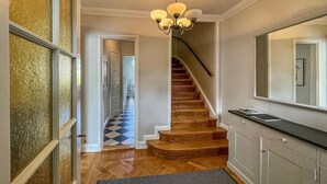 A hallway with a wooden staircase, a chandelier, and a patterned rug. - Amazing home in Göteborg with WiFi (Göteborg)