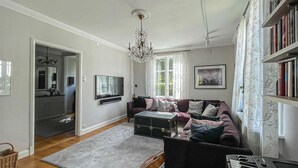 A living room with a sofa, a television, a chandelier, and a bookshelf. - Amazing home in Göteborg with WiFi (Göteborg)