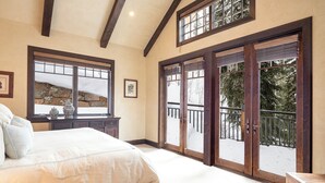 A bedroom with a large bed, a dresser, and a window with a view of a snowy landscape. - Stay on Forest Road! Walk to Lionshead! (Vail)