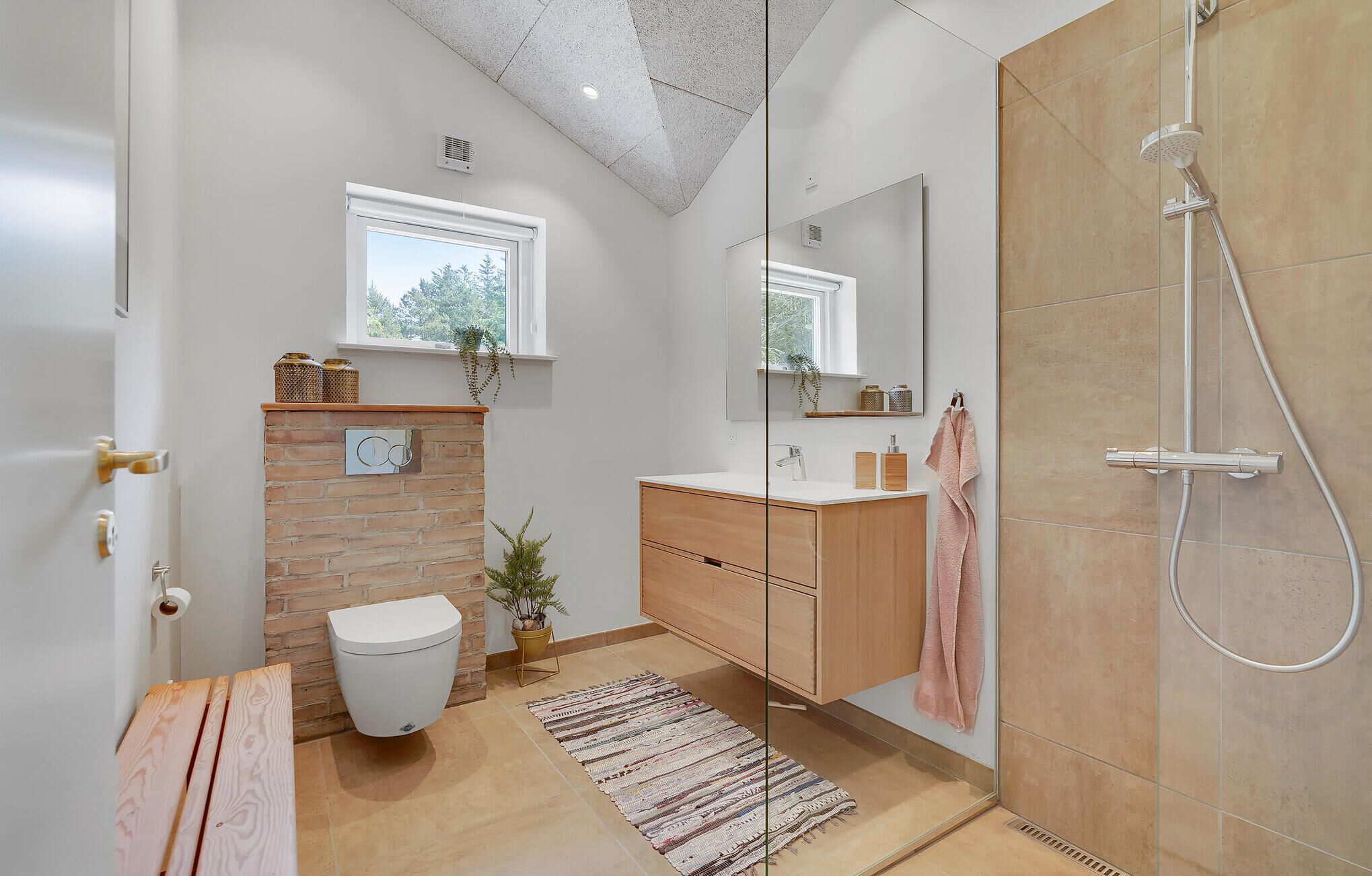 A modern bathroom with a toilet, sink, and shower.