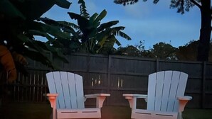 A fire pit with two Adirondack chairs in a backyard setting. - Private home in Mt. Pleasant, SC Vacation Rental 10 min drive to the beach. (Mount Pleasant)