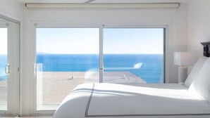 A hotel room with a large bed, a ceiling fan, and a view of the ocean through a sliding glass door. - Oceans Views Zen Retreat | 6 Min Walk to Beach | Dolphin Spotting | Pet OK (Malibu)