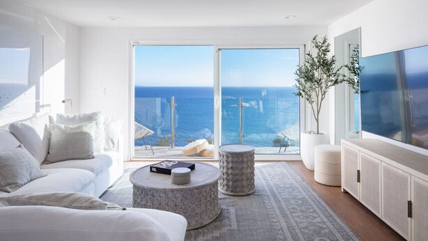A modern living room with a large window offering a view of the sea. - Oceans Views Zen Retreat | 6 Min Walk to Beach | Dolphin Spotting | Pet OK (Malibu)