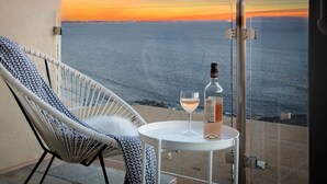 A balcony with a white chair, a small table, a bottle, and a glass of wine. - Oceans Views Zen Retreat | 6 Min Walk to Beach | Dolphin Spotting | Pet OK (Malibu)