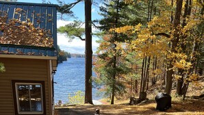 A wooden deck leading to a cabin with a stone pathway. - Lakefront Cottage near Adirondacks, Pontoon Boat, Sunroom, 2 Kayaks & Canoe (Hermon)