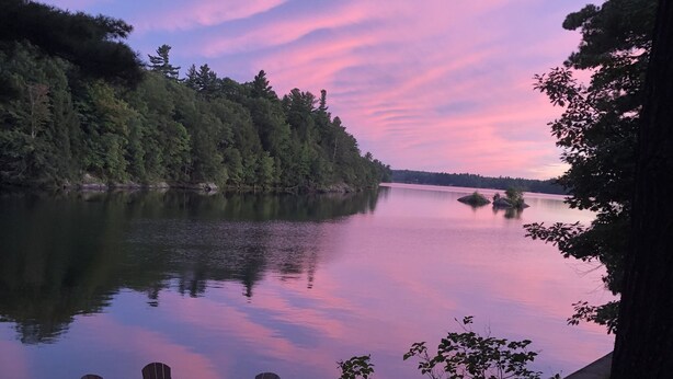 A lakeside view with a fire pit and Adirondack chairs. - Lakefront Cottage near Adirondacks, Pontoon Boat, Sunroom, 2 Kayaks & Canoe (Hermon)