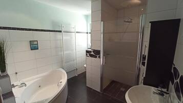 Bathtub, hair dryer, towels, toilet paper