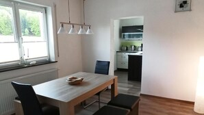 A modern kitchen with white cabinets and a black countertop. - Urlaub in Ländlicher Umgebung (Illschwang)