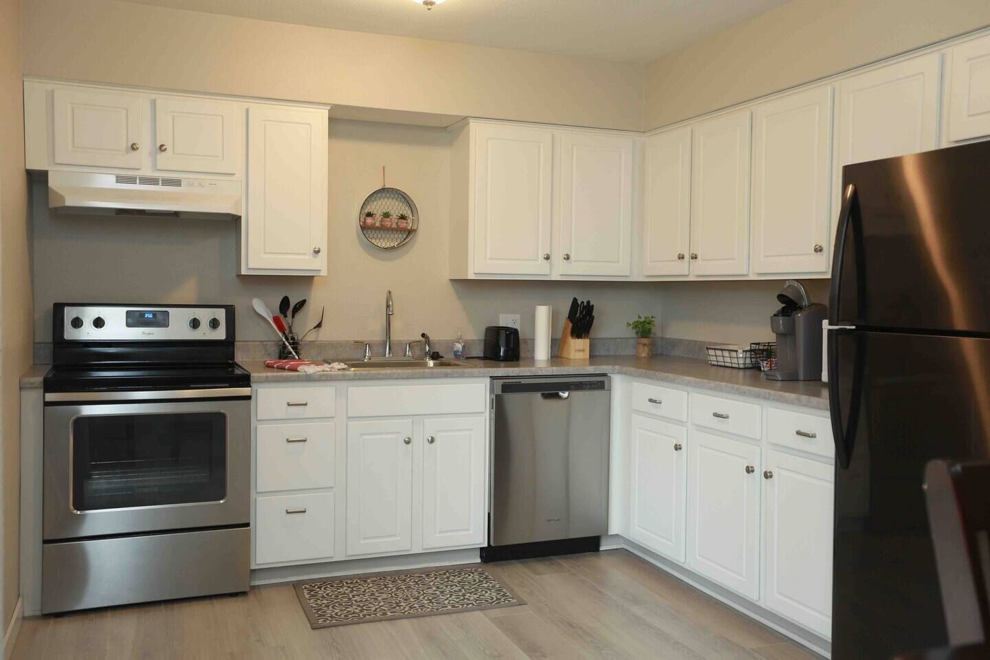 A modern kitchen with white cabinets, stainless steel appliances, and a central island.