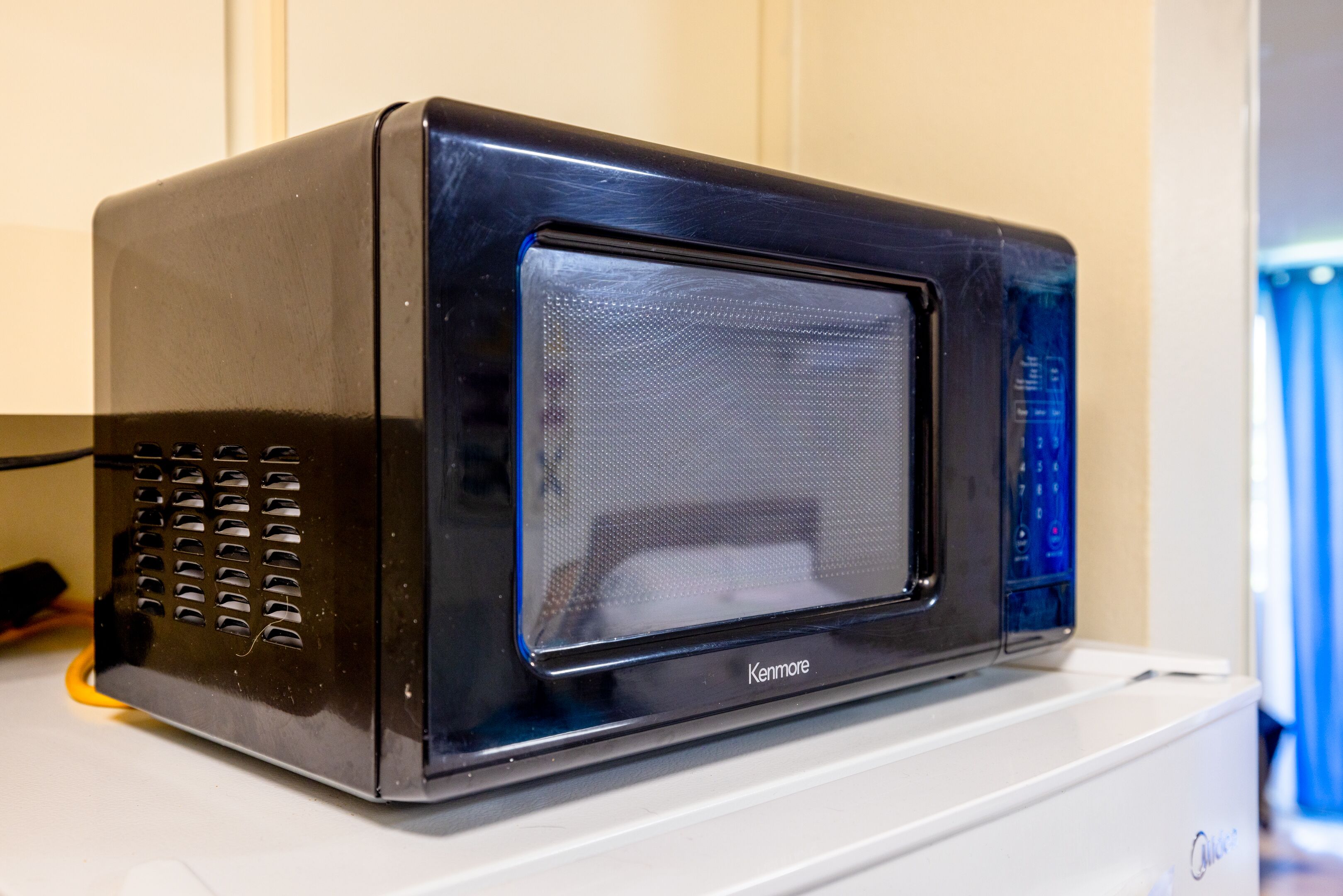 Um forno micro-ondas Kenmore sobre uma bancada branca.