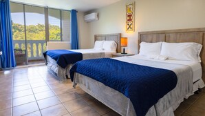A hotel room with two beds, a balcony with blue curtains, and a wall-mounted air conditioner. - Golden Dream Studio 306 B (Isabela)