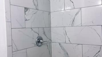 Tina con regadera, secadora de cabello, toallas, papel de baño